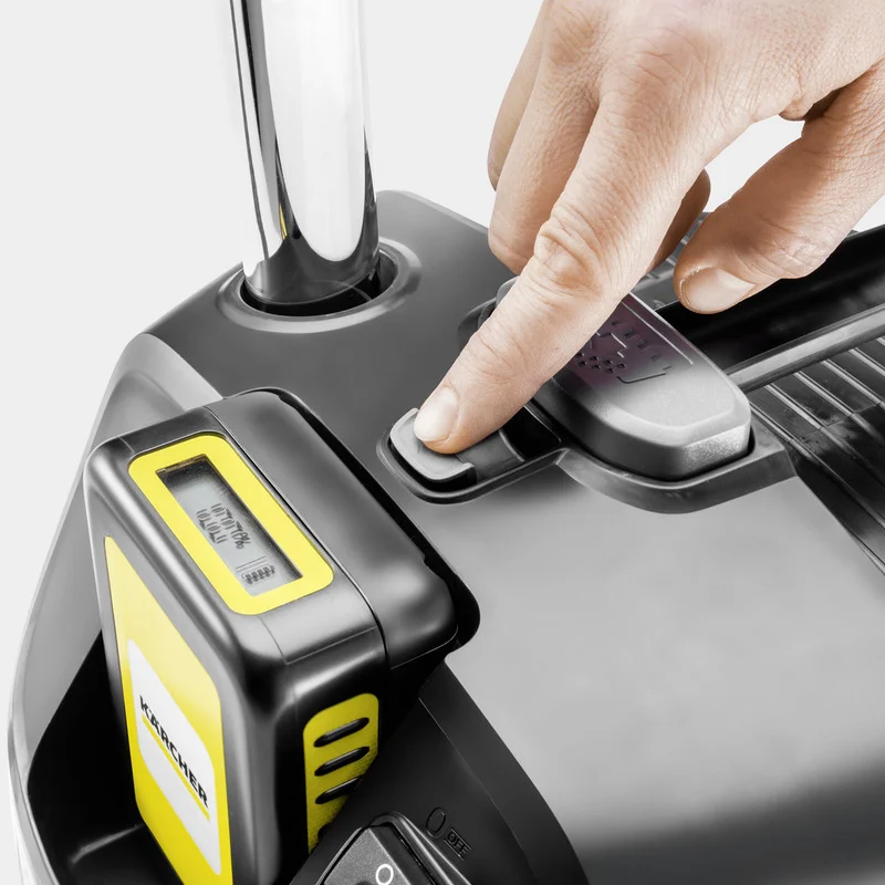 Hand drückt Taste auf Kärcher Gerät mit gelbem Display und silbernem Griff.