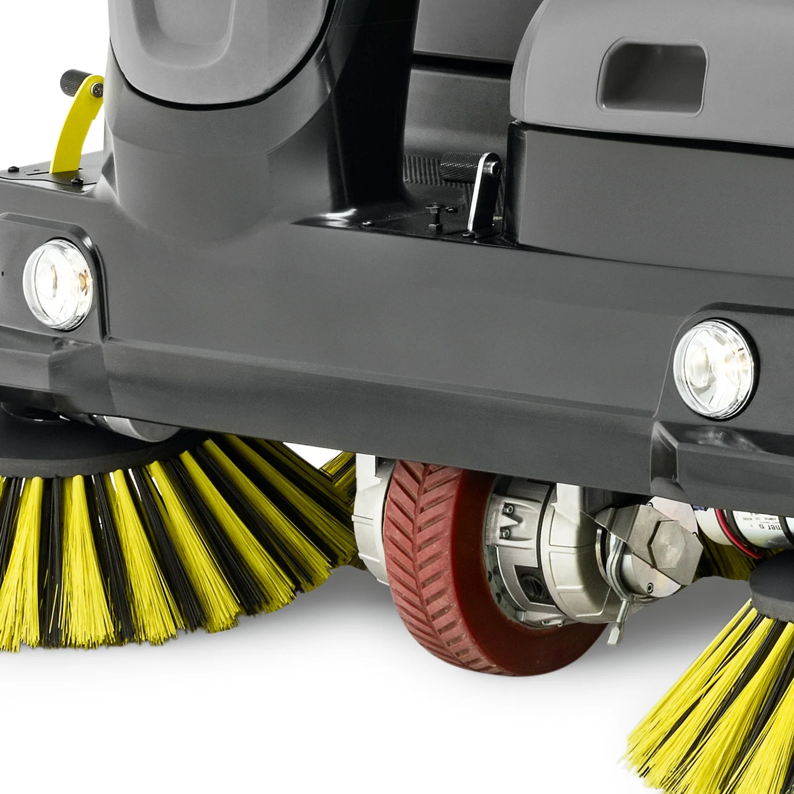 Nahaufnahme einer Kehrmaschine mit gelben Bürsten und roten Rädern, zwei Scheinwerfer sichtbar.