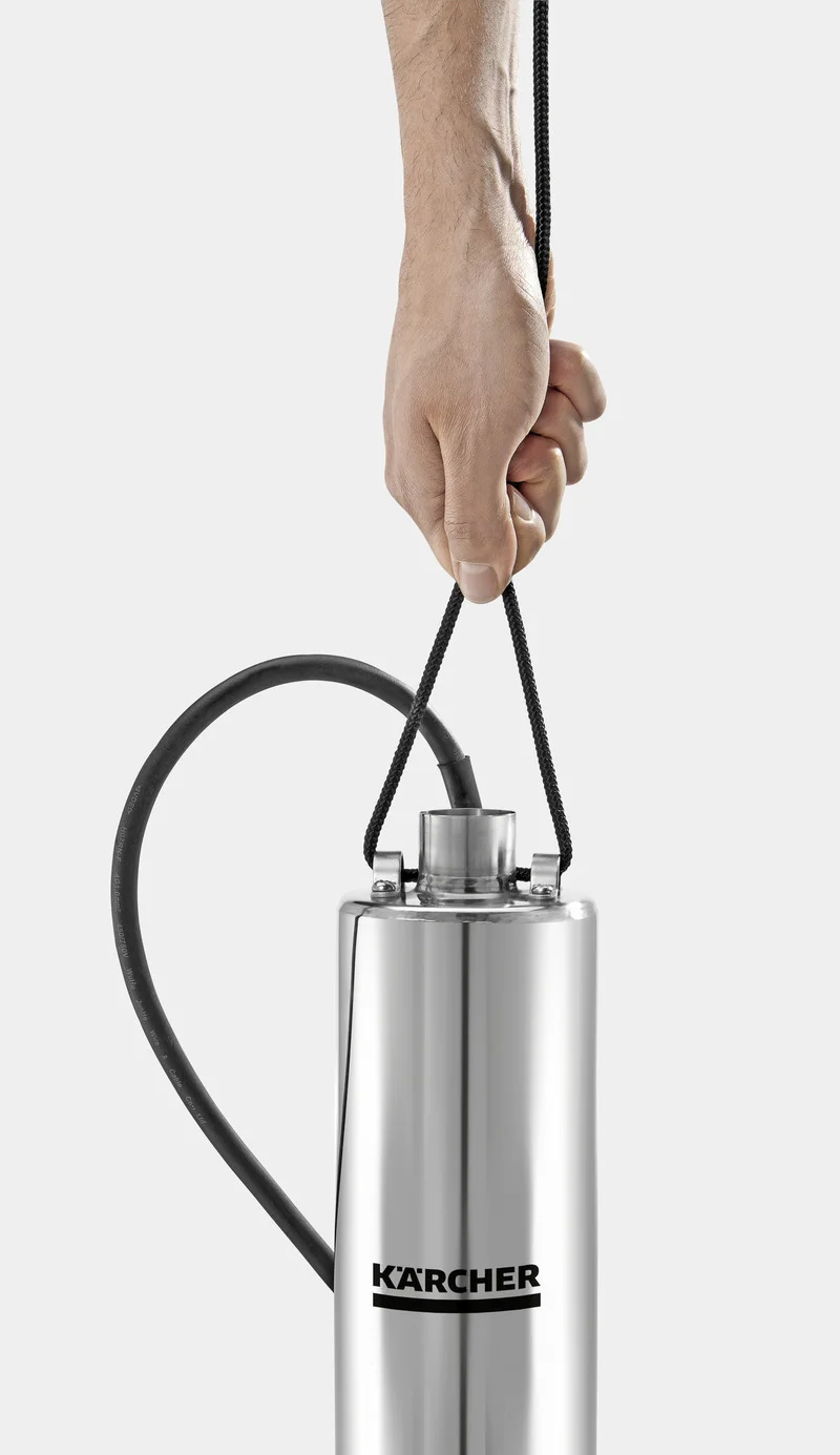 Hand hält Kärcher Tauchpumpe mit schwarzem Kabel, silbernes Gehäuse, vor grauem Hintergrund.
