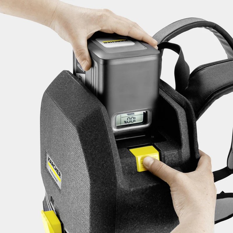 Hand setzt Akku in Kärcher Rucksackgerät ein, Display zeigt 77% Ladung.