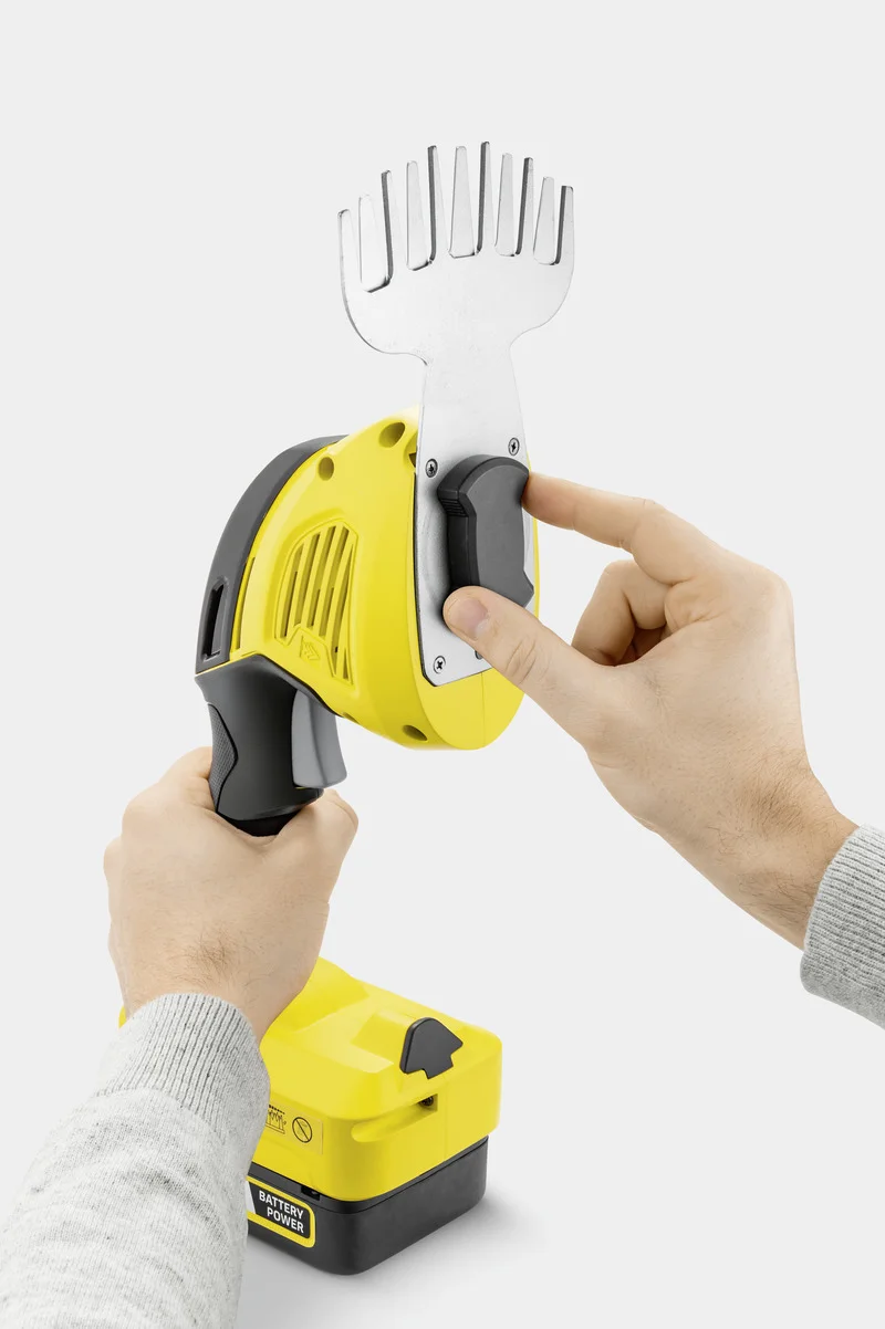 Zwei Hände halten einen gelben Kärcher Akku-Unkrautentferner, eine Hand justiert den Metallaufsatz.