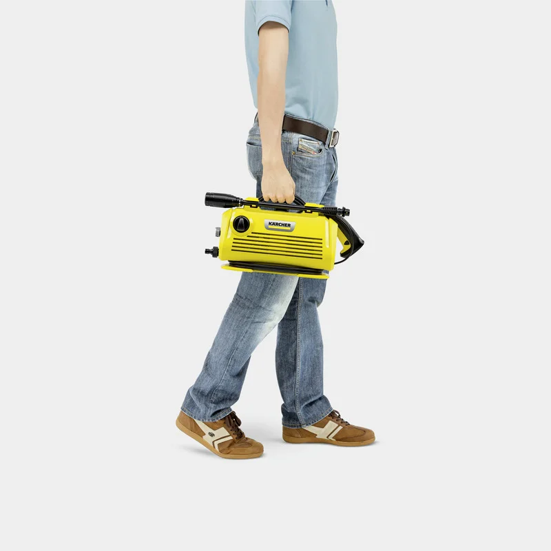 Mann in Jeans und blauem T-Shirt trägt einen gelben Kärcher Hochdruckreiniger.