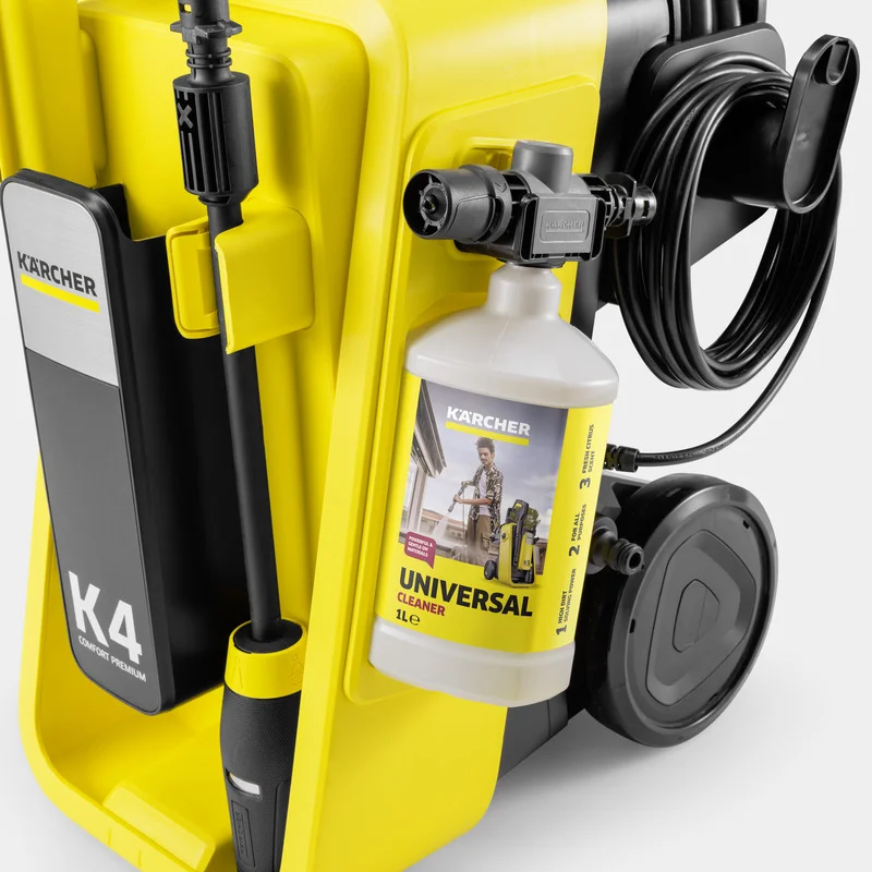 Kärcher K4 Hochdruckreiniger mit angeschlossener Universal-Reinigungsmittelflasche, gelb-schwarzes Design, Kabel und Schlauch sichtbar.