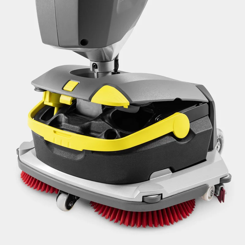 Kärcher Bodenreinigungsmaschine mit roten Bürsten, grauem Gehäuse und gelben Akzenten auf weißem Hintergrund.