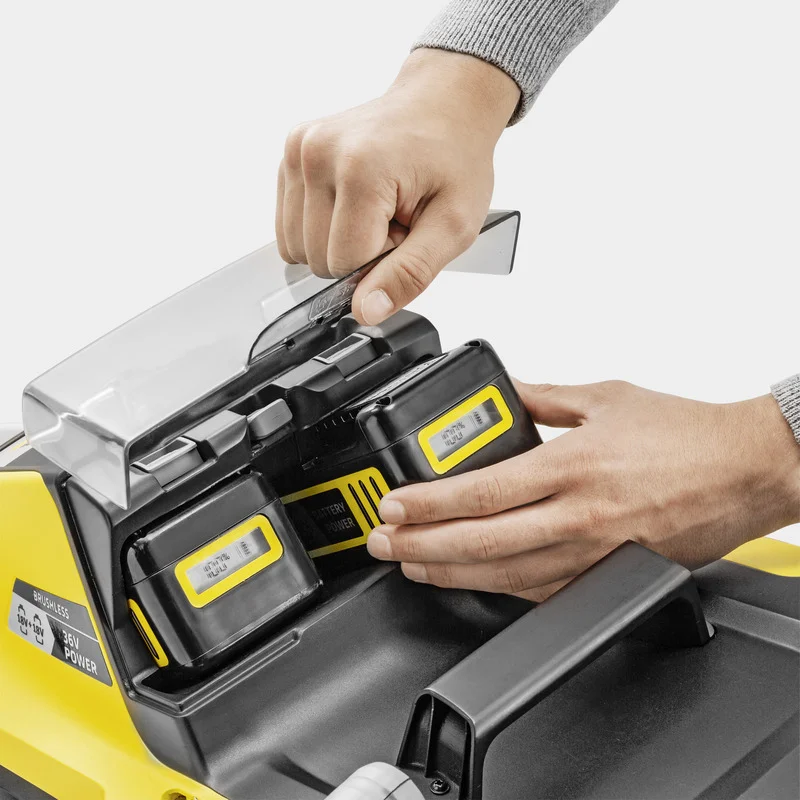 Hände setzen Akkus in einen Kärcher 36V Power-Akkuhalter ein, mit transparentem Deckel.