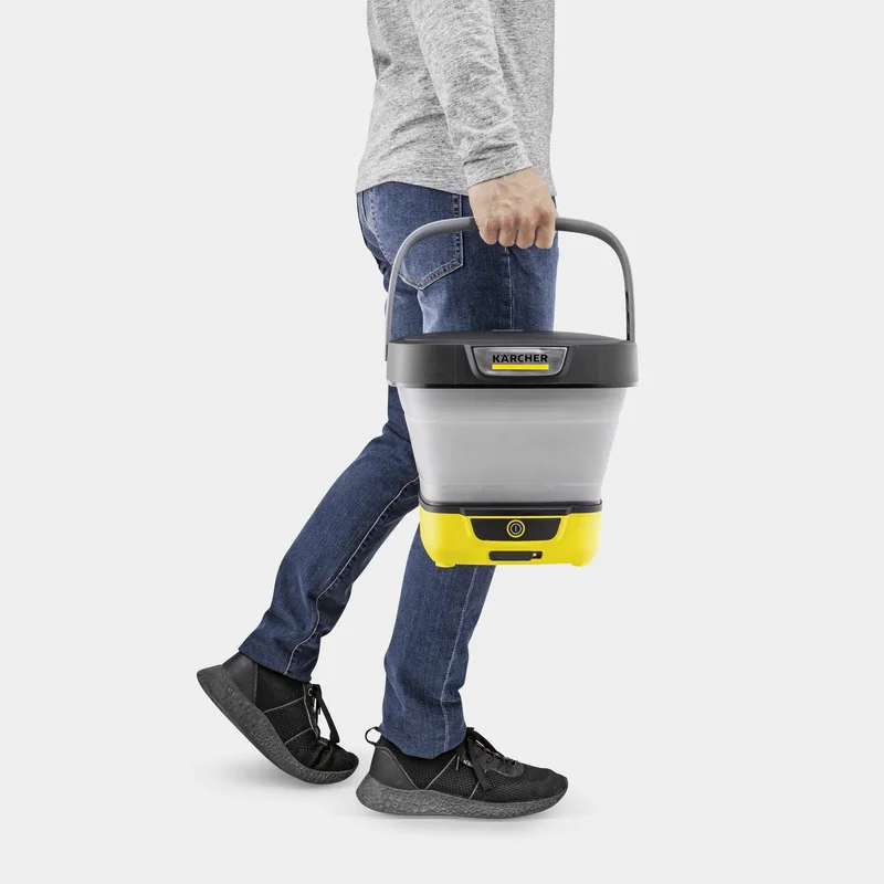 Person trägt einen Kärcher Eimer in der Hand, gekleidet in graues Shirt und blaue Jeans, schwarze Schuhe.