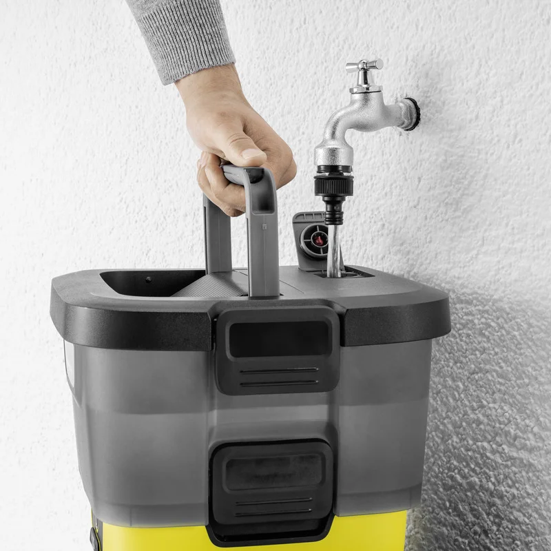 Hand hält Kärcher Hochdruckreiniger unter Wasserhahn, Wasser fließt in Gerät, graue Wand im Hintergrund.
