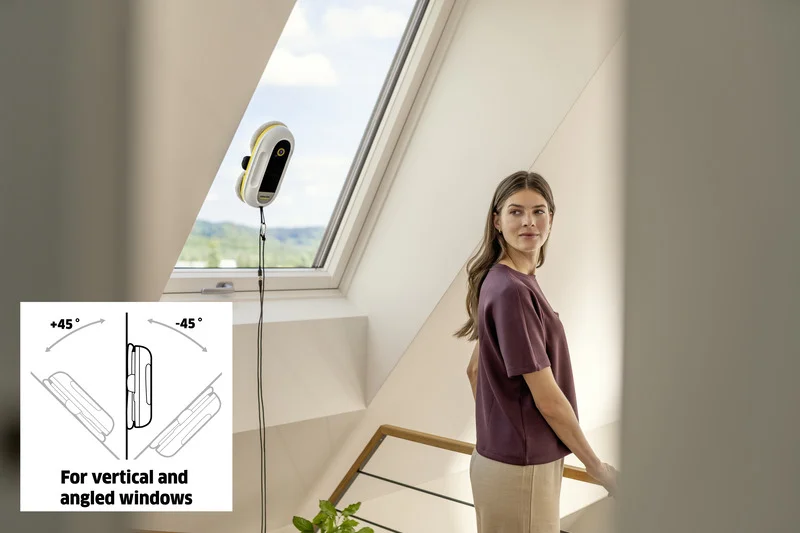 Frau in einem Innenraum, während ein Kärcher Fenstersauger an einem Dachfenster angebracht ist. Sie blickt zur Kamera.