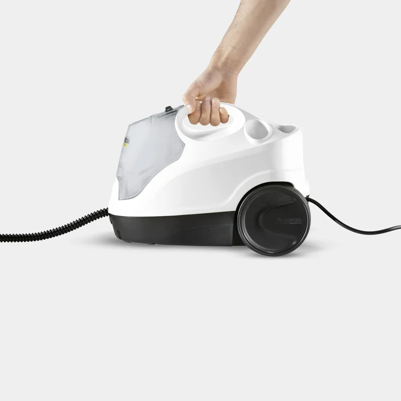 Hand hält einen weißen Kärcher Dampfreiniger mit schwarzen Rädern und Kabel auf grauem Hintergrund.