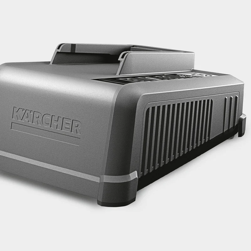 Graues Kärcher Batterieladegerät mit Lüftungsschlitzen, seitliche Ansicht auf hellem Hintergrund.