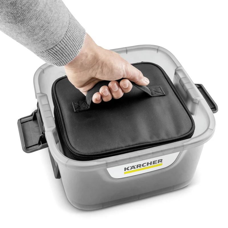 Hand greift nach schwarzem Griff einer Kärcher Aufbewahrungsbox mit transparentem Deckel.
